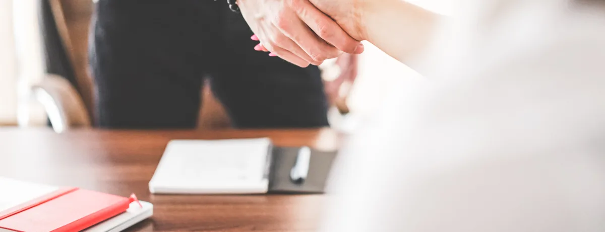 Twee ondernemers geven elkaar een hand in een kantoor